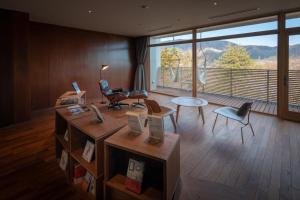 a living room with a large window and a table and chairs at Hakone Honbako 箱根本箱 in Hakone