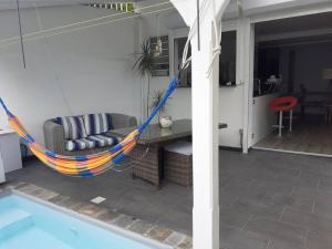 - un hamac sur une terrasse à côté de la piscine dans l'établissement T2 design pour 2 à Anse à l'Âne aux Trois Ilets, à Les Trois-Îlets