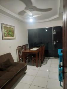 a living room with a table and a couch at Apartamento Ubatuba 150m do mar Maranduba in Ubatuba