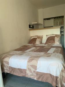 1 dormitorio con 1 cama grande con sábanas blancas y marrones en Studio à mantes, en Mantes-la-Jolie