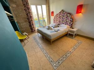 - une chambre avec un lit, une chaise et un tapis dans l'établissement Mama Souiri Hotel, à Essaouira