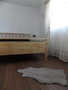 sypialnia z drewnianym łóżkiem i dywanem w obiekcie Cabana Telescaun w mieście Petroszany