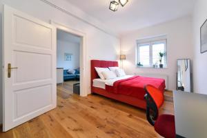 a bedroom with a red bed and a door at Cosy Lu Apartment in Zagreb