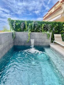 a swimming pool with a fountain in a yard at The Retreat House - Private Pool in Puerto de Santiago