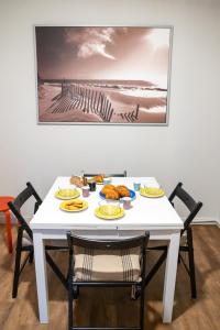 une table blanche avec des assiettes de nourriture dans l'établissement Stuart, à Dinard