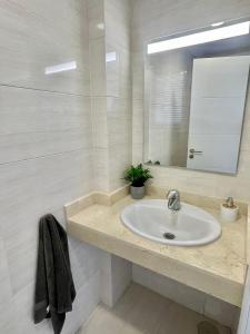 een witte badkamer met een wastafel en een spiegel bij The Retreat House - Private Pool in Puerto de Santiago