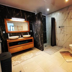 a bathroom with a sink and a shower with a mirror at Le Refuge d'Heva in Salazie