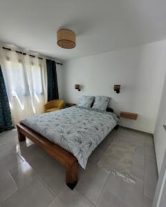 una camera con un letto in una stanza con finestre di Le Refuge d'Heva a Salazie