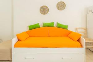 een oranje bed met groene kussens in een slaapkamer bij [Stellantis-Alpitour] Casa Tucano in Turijn