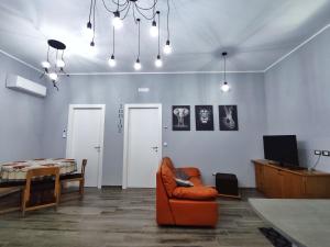 een woonkamer met een oranje stoel en een tafel bij The Junior House - Casa Vacanza in Lauria Inferiore