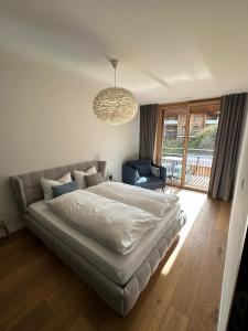 1 dormitorio con cama y lámpara de araña en Beautiful Sunny New 1 Bed Apt (2.5Zim). Ski in/out, en Flims