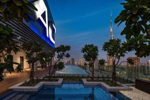 杜拜的住宿－Paramount Midtown Deluxe 1 BR Apartment with Full Burj-Khalifa View，城市天际线游泳池的 ⁇ 染
