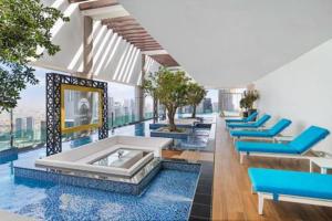 杜拜的住宿－Paramount Midtown Deluxe 1 BR Apartment with Full Burj-Khalifa View，一间设有蓝色椅子的房间和一个游泳池