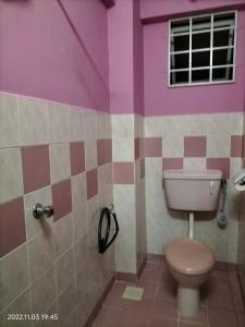 een badkamer met een toilet en een paarse muur bij A room in Aparnt Sri Impian in Johor Bahru