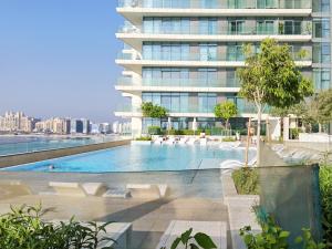 een afbeelding van een groot gebouw met een zwembad bij 2BR Amazing Palm View - Private beach - Beach Vista T1 in Dubai