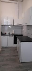 cocina con armarios blancos y encimera negra en Apartament w Centrum, en Sulechów