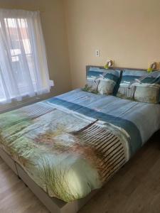 een groot bed in een slaapkamer met een raam bij Zandput nr 30 in Zoutelande
