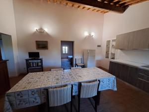 eine Küche mit einem Tisch und Stühlen im Zimmer in der Unterkunft Casa Daria, Armonia del Passato nel rispetto della natura in Donoratico