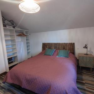 003 QUIN - Maison du Maine في Grand-Village-Plage: غرفة نوم بسرير كبير مع لحاف احمر