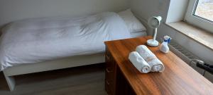 ein Schlafzimmer mit einem Bett und einem Holztisch mit Handtüchern in der Unterkunft Hanover Fair Rooms in Hannover