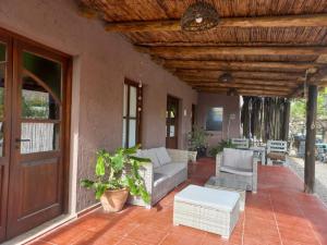 porche con sofá, sillas y puerta en Cazasanta en Mendoza