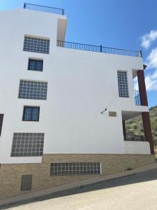 Carchelejo的住宿－ALOJAMIENTO Rural AVD SIERRA MÁGINA，一座白色的建筑,上面有太阳能电池板