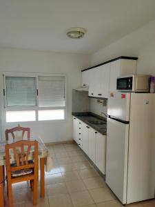 eine Küche mit einem weißen Kühlschrank und einem Tisch in der Unterkunft Apartamento Céntrico Puerto Del Rosario in Puerto del Rosario