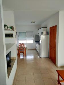 eine Küche mit einem Kühlschrank und einem Tisch mit einem Esszimmer in der Unterkunft Apartamento Céntrico Puerto Del Rosario in Puerto del Rosario