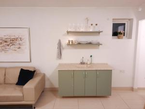 een woonkamer met een wastafel en een bank bij Casa Køster studio in Odense