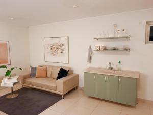 ein Wohnzimmer mit einem Sofa und einem Waschbecken in der Unterkunft Casa Køster studio in Odense