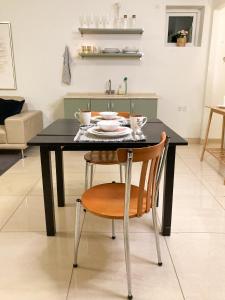 een zwarte eettafel met een houten stoel bij Casa Køster studio in Odense