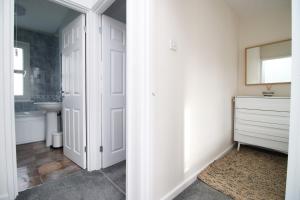 a bathroom with a white door and a sink at K Suites - Selkirk Street in Cheltenham +25 photos