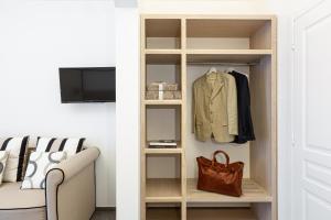 a closet with a shelf with a jacket and a purse at la dimora di Cornelia in Sorrento