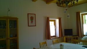 a dining room with a table and a television at Villa Giulia Vendégház in Verpelét