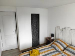 um quarto com uma cama e uma parede branca em Agréable chambre d'hôte 