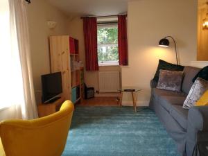 uma sala de estar com um sofá e uma televisão em Gorgeous private apartment mesmerising sea views em Teignmouth