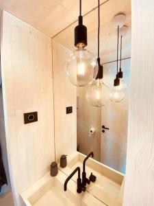 uma casa de banho com um lavatório, um espelho e luzes em BUQEZ ECO RESORT - Beach Villa 28 - Directly by beach em Drage