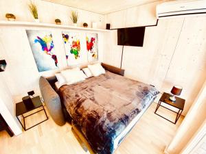 uma cama grande num quarto com pinturas na parede em BUQEZ ECO RESORT - Beach Villa 28 - Directly by beach em Drage