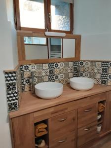 uma casa de banho com 2 lavatórios num balcão de madeira em Gite de la tour em Plancherine