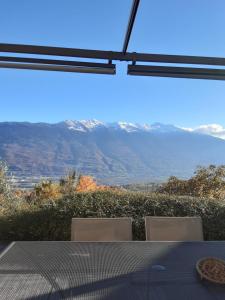 uma mesa e cadeiras com vista para as montanhas em Gite de la tour em Plancherine