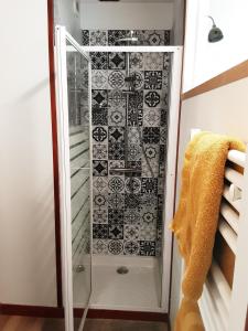 eine Dusche mit einer schwarz-weißen Kachelwand in der Unterkunft Gite de la tour in Plancherine