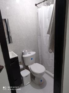 een kleine badkamer met een toilet en een douche bij Posada Miss Mazie in San Andrés