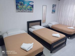duas camas num quarto com duas camas de cabeceira em Posada Miss Mazie em San Andrés