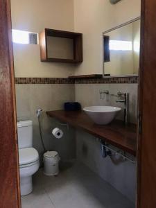 y baño con lavabo, aseo y espejo. en Nova Casa Laranjeiras, en Garopaba