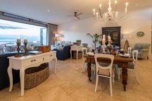 a living room with a table and chairs and a dining room at The Upper Deck Penthouse Plettenberg Bay in Plettenberg Bay