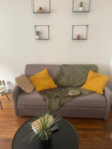 uma sala de estar com um sofá cinzento com almofadas amarelas em Le Gambetta 4 - halles de Merville - T3 - centre ville em Lorient