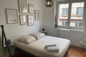 um quarto com uma cama com duas toalhas em Le Gambetta 4 - halles de Merville - T3 - centre ville em Lorient