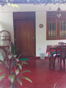 Pokój ze stołem i drewnianymi drzwiami w obiekcie Yunal's Place w mieście Matara