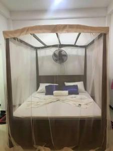 sypialnia z łóżkiem z baldachimem i niebieskimi poduszkami w obiekcie Yunal's Place w mieście Matara