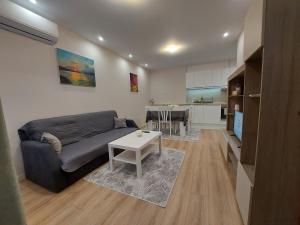 a living room with a couch and a table at White grapes apartment in Petrich